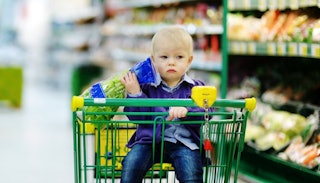 A small boy sitting in a shopping cart