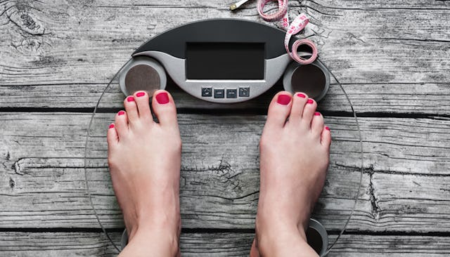 A woman measuring her weight on a scale