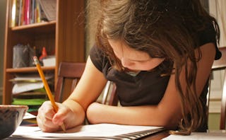 A girl whose mom is a Latina Tiger Mom sitting and doing her homework