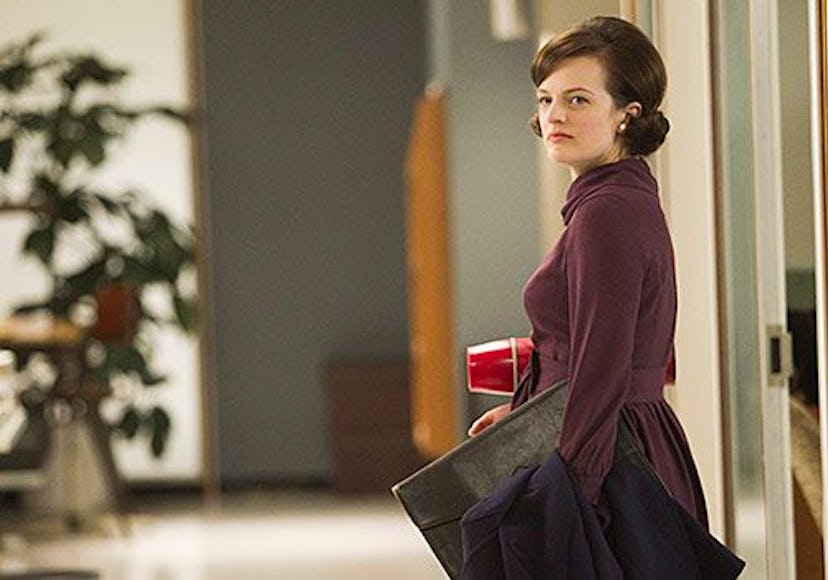 Peggy from Mad Men series standing in the hallway and looking into the distance 