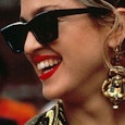 Madonna wearing red lipstick, black sunglasses, and large pharaoh-shaped earrings in 'Desperately Se...