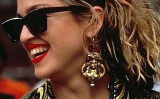 Madonna wearing red lipstick, black sunglasses, and large pharaoh-shaped earrings in 'Desperately Se...