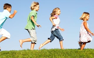 Four happy kids running down a valley