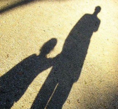 Two shadows in the sun - father and son holding hands 