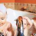 Two toddlers and one slightly older child in a bathtub taking a bubble-bath