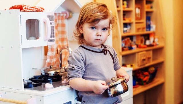 A kid doing chores in a little kitchen