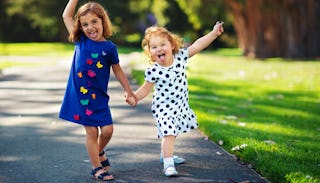 Two happy girls goofing around together having their tongues out in a park