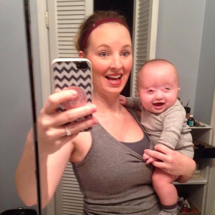 A mother with her baby taking picture in the mirror.
