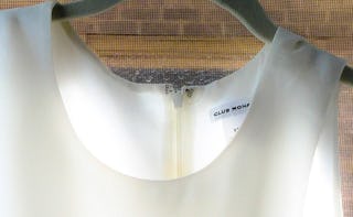 A close-up of a white dress on a black hanger