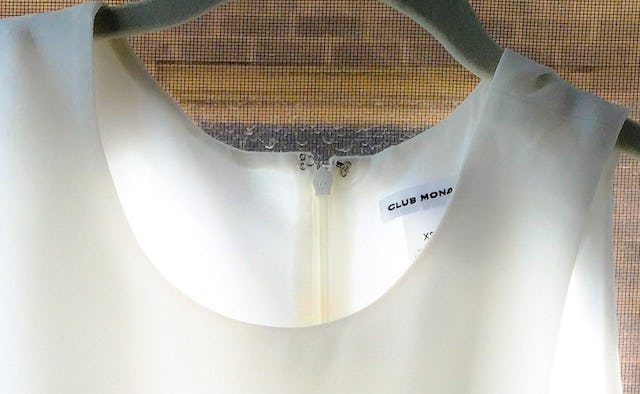 A close-up of a white dress on a black hanger