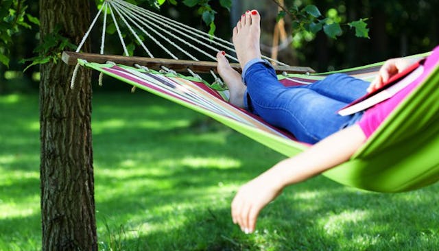A lazy mom relaxing on a swing with a book