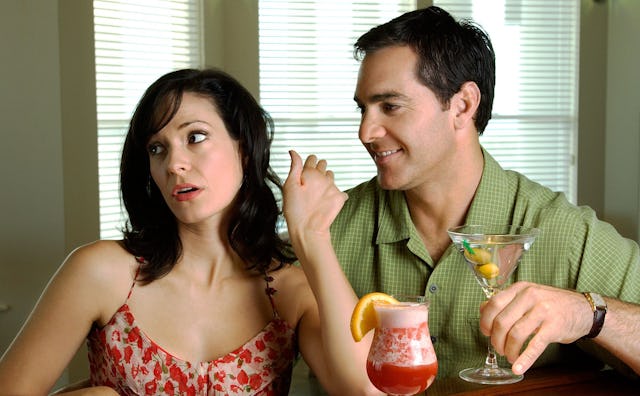A couple on a first date having drinks, woman disinterested because the man said something stupid