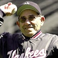 A famous American professional baseball catcher Yogi Berra holding a baseball in his hand while smil...