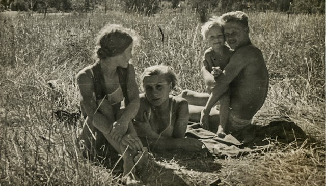 Mom, dad, and kids sitting on a field in the 70s
