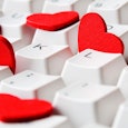 A white keyboard with red hearts in between the keys representing OkCupid