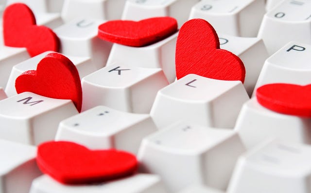 A white keyboard with red hearts in between the keys 