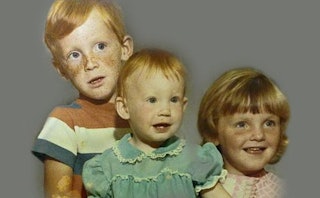 Three redheaded children and one is smiling, the second looking serious, and the third looking curio...