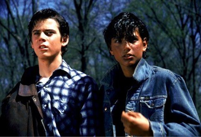 Ponyboy Curtis in a plaid blue shirt with a friend, played by C. Thomas Howell in the movie "The Out...