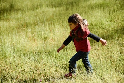 child striding through meadow