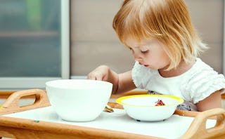 A little girl with ADHD eating her food from the dining table