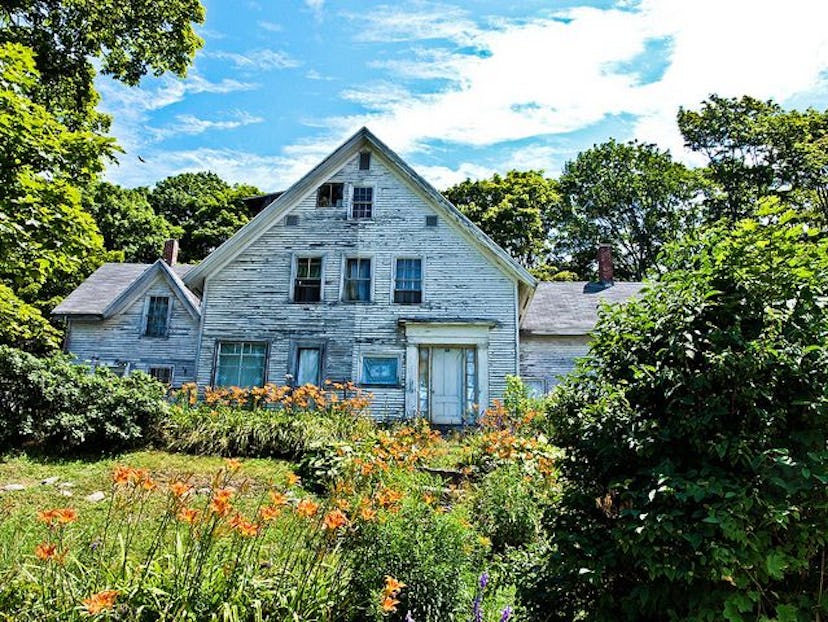 A large white old house in nature during day time