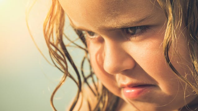 A 3-year-old girl with a sad facial expression as if about to cry 