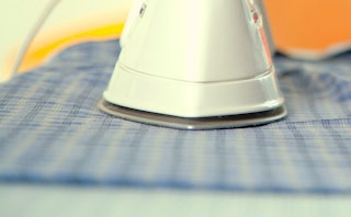 A closeup of an electric iron pressing clothing