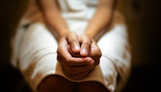 Woman anxiously holding her hands on her lap 