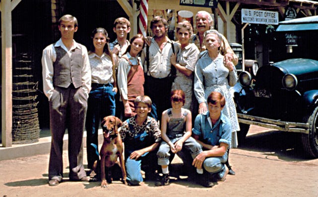 Grandparents, parents, kids, and a dog all posing for a picture next to a post office