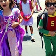 Nerd kids; a boy in a DC Robin costume and a girl in a pink and purple Rapunzel princess costume