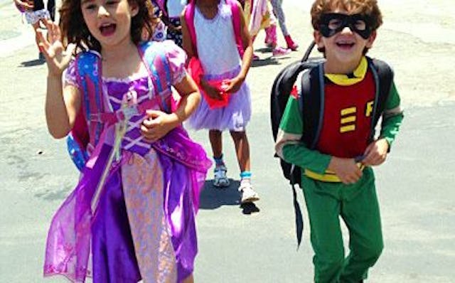 Nerd kids: a boy in a DC Robin costume and a girl in a pink and purple Rapunzel princess costume
