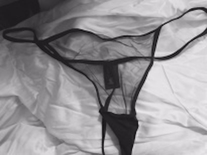 Black semi-see thongs on white bed sheets