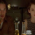  Ethan Hawke in a burgundy shirt drinking a coke and Wynona Rider in a sleeveless top sitting at a t...