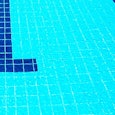 A big swimming pool with clean water and teal tiles.