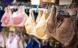 Pink, yellow, blue, and brown bras on hangers in an underwear shop