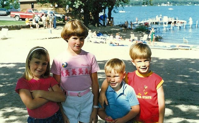 Two little girls and two little boys at the beach during a 1980s summer