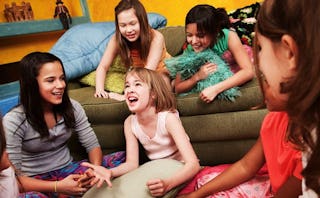 Five girls sitting in a living room and having a sleepover