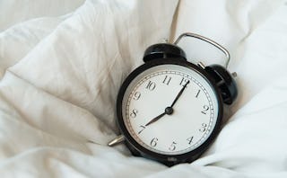 An analog clock on the bed which symbolizing turning 43 but still not wanting children