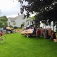 Different types of people at a yard sale with a lot of things displayed there