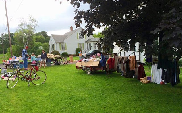 Different types of people at a yard sale with a lot of things displayed there