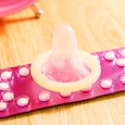 A condom laying on the contraceptive pills
