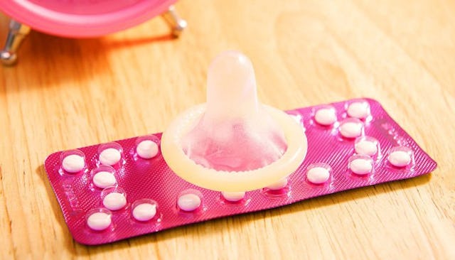 A condom laying on the contraceptive pills
