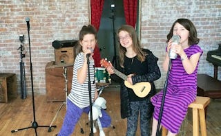 Three girls singing songs that helped their mom and dad parent in their 40s