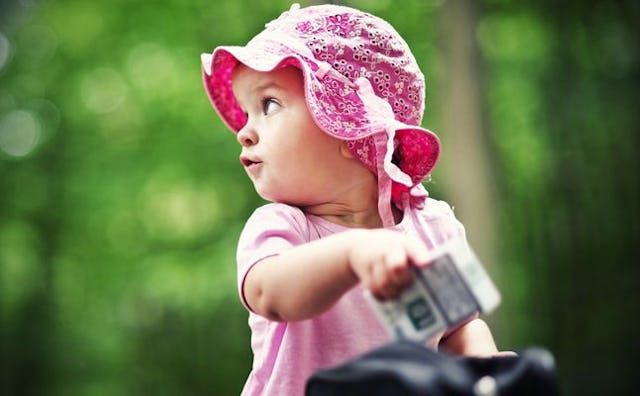 A baby girl wearing a pink cap and shirt just like her mommy