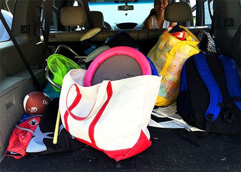 A car trunk with large tote bags and beach essentials