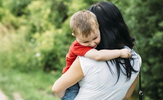 A grieving mother holding her son while walking outside