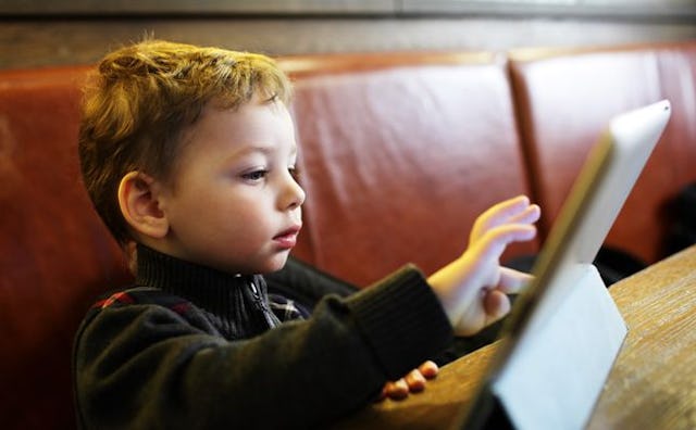 A child playing with a tablet at a restaurant