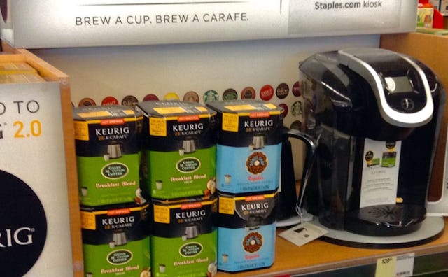 A coffee machine and different flavors of coffee on a store shelf in a dorm room