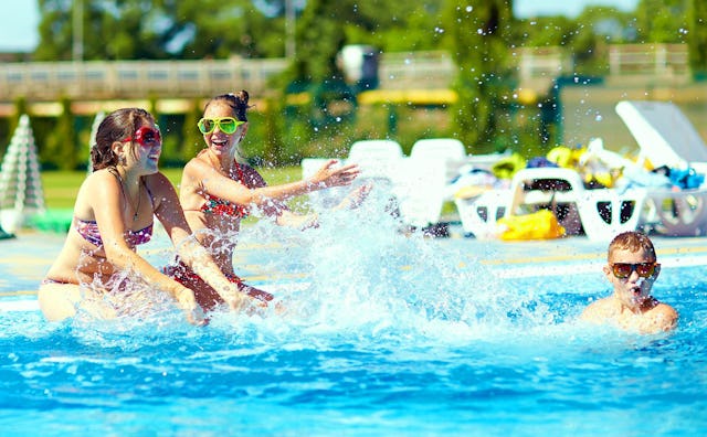 Three kids playing at a public pool as a Summer's Nostalgia Factor