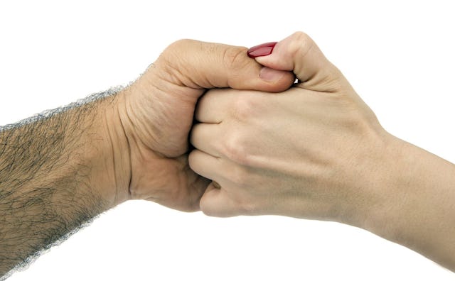 A woman holding hands with a hairy man